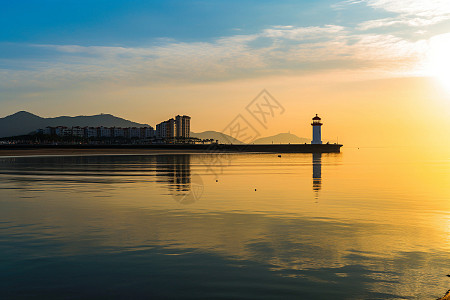 海上日出时的青岛情人坝和灯塔高清图片下载-正版图片501707870-摄图网
